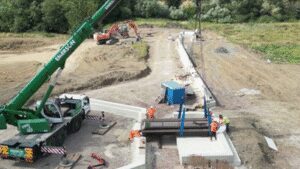 An English town installed a six-metre swing bridge whose deck contains the equivalent of 140 recycled plastic bottles per square metre and can be manually opened for passing boats